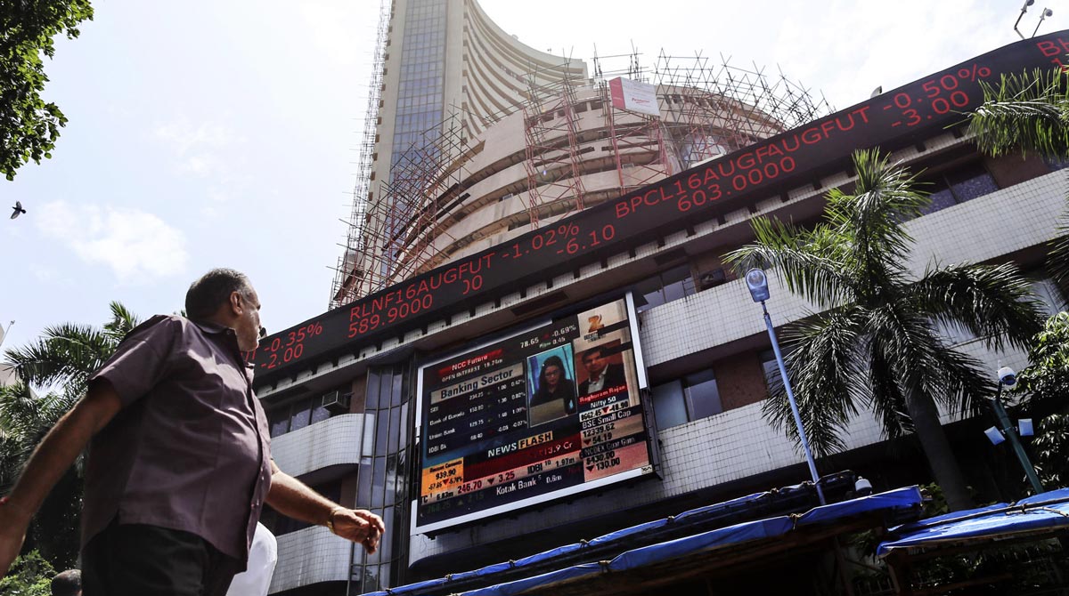 Пешеходы, идущие мимо электронного табло Бомбейской фондовой биржи в Мумбаи, Индия.
