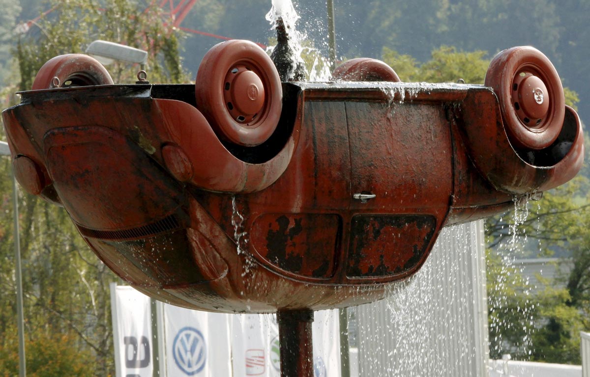 Перевернутый Volkswagen Beetle, часть скульптурного фонтана перед фасадом швейцарского филиала Volkswagen, в городе Buchs недалеко от Цюриха.