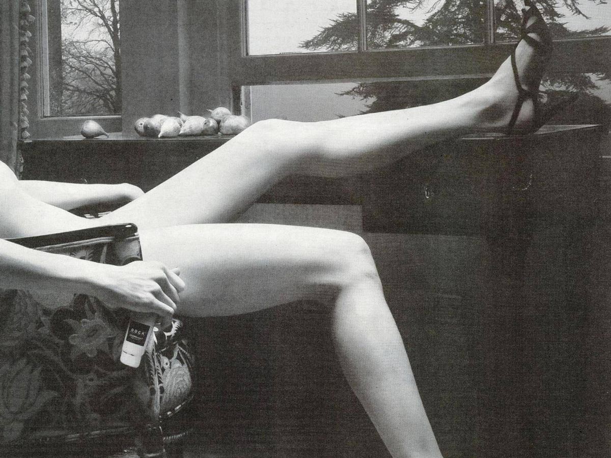 В запрещенном рекламном объявлении было черно-белое изображение явно обнаженной женщины, носящей только пару ремешков, лежащей в кресле с одной ногой, закинутой на стол, и другой, опущенной на пол.
