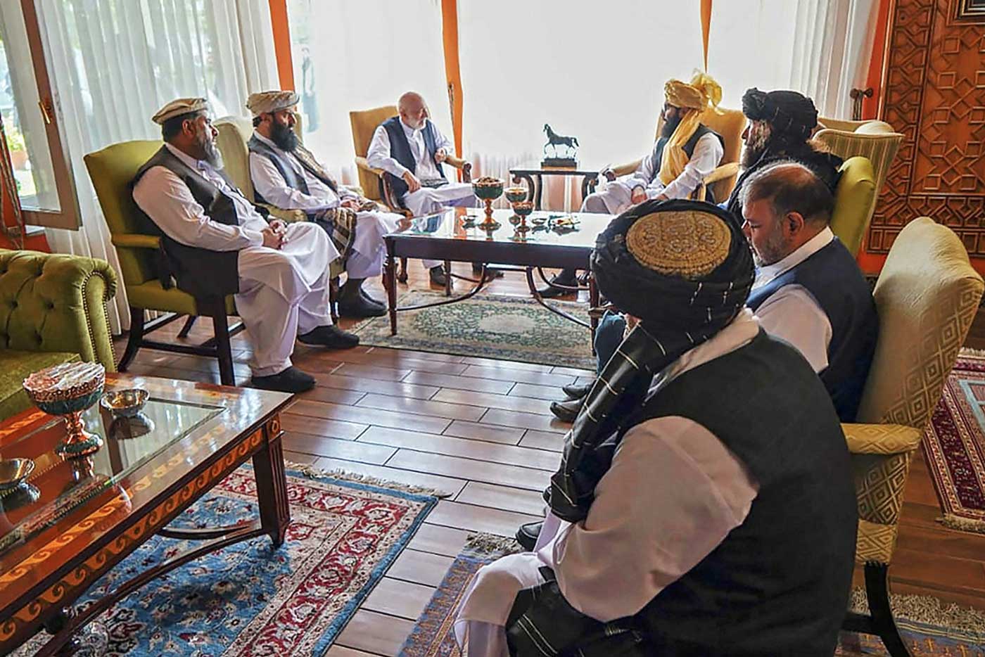 Делегация талибов во главе с руководителем команды переговорщиков, Анасом Хаккани (Anas Haqqani) (в центре справа), встречается с чиновниками бывшего афганского правительства, в том числе с бывшим президентом Хамидом Карзаем (в центре справа), в неопределенном месте в Афганистане в середине августа.
