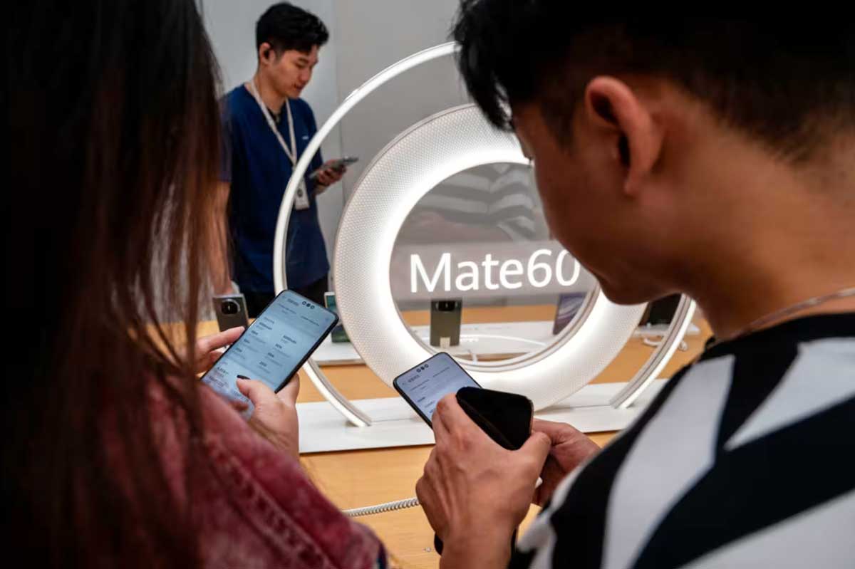 Люди пробуют новый смартфон Mate 60 в флагманском магазине Huawei в Пекине.