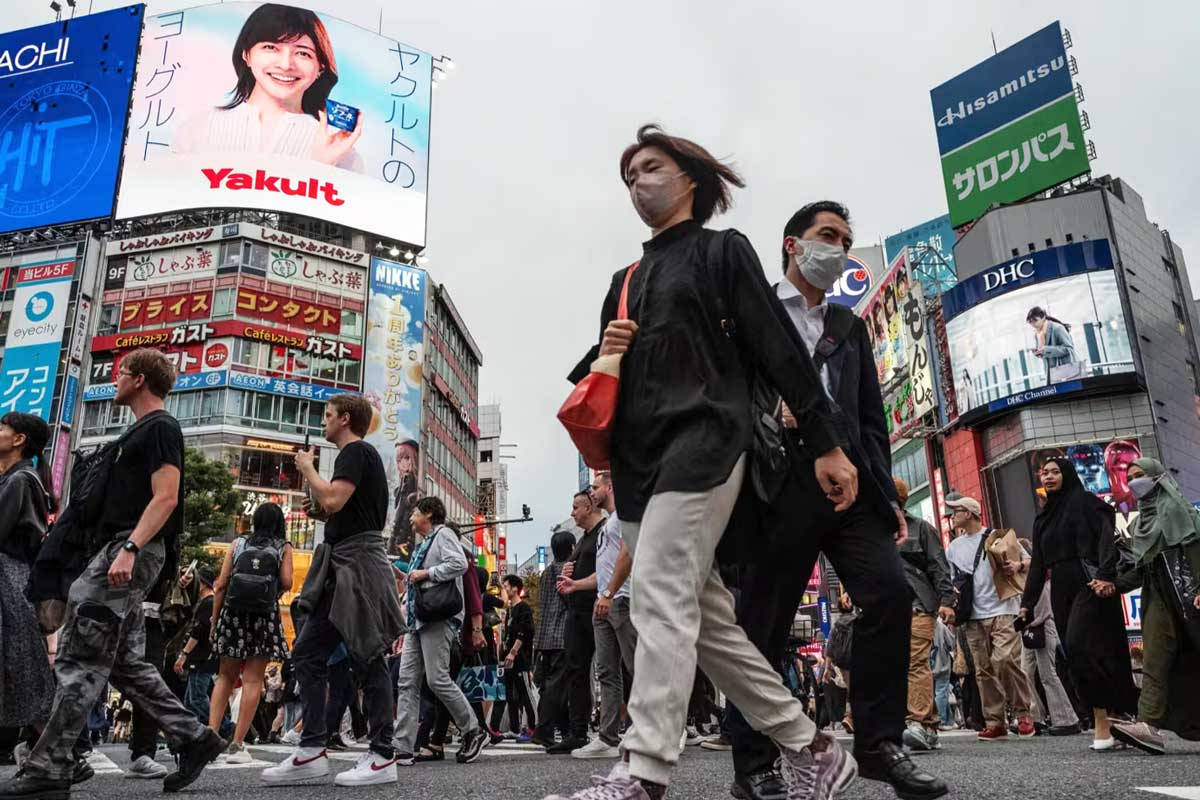 Пешеходы на Сибуйском пешеходном переходе в центральном Токио. Многие молодые работающие японцы считают, что экономика закрыта для них.