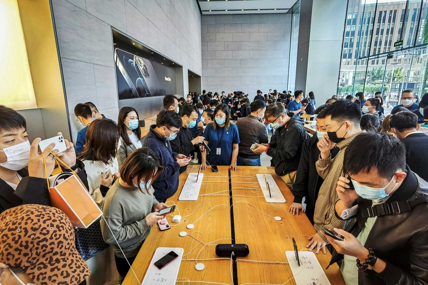 Посетители магазина Apple в Шанхае пробуют смартфоны iPhone 12.