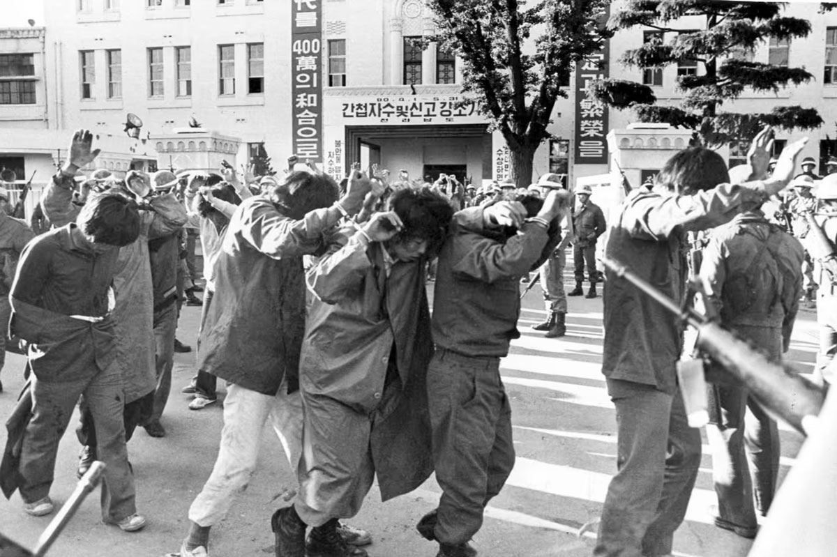 Задержанные протестующие под конвоем вооруженных солдат в Кванджу, 1980 год.