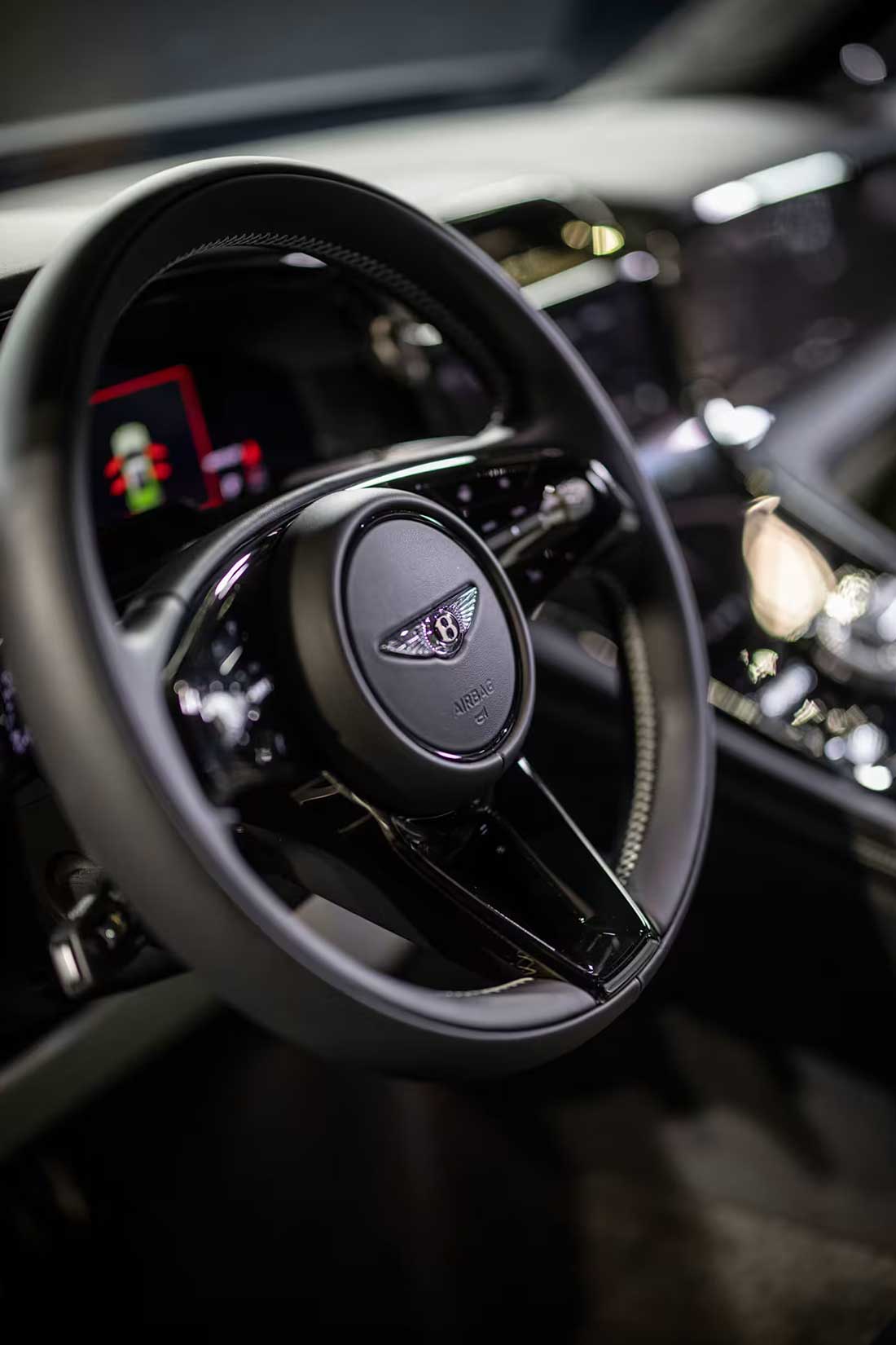 Крупный план рулевого колеса и приборной панели Bentley Torcal. Звук движения автомобиля создан вручную музыкантами с использованием звуков перкуссии, хрустального стекла, птиц и постукиваний по коже.