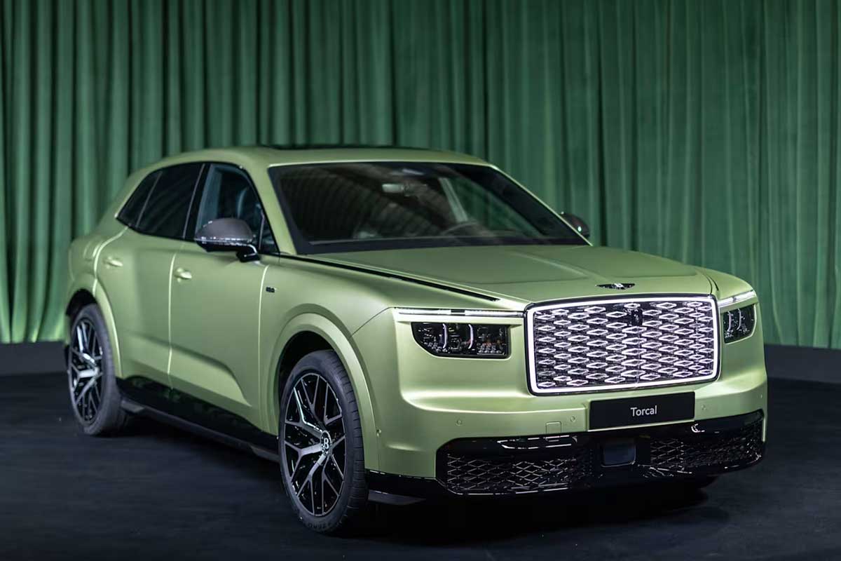Bentley Torcal, новый электрический внедорожник, представлен на черной платформе с зеленым занавесом. Стартовая цена Torcal составляет £173,300, а запас хода - до 600 км.